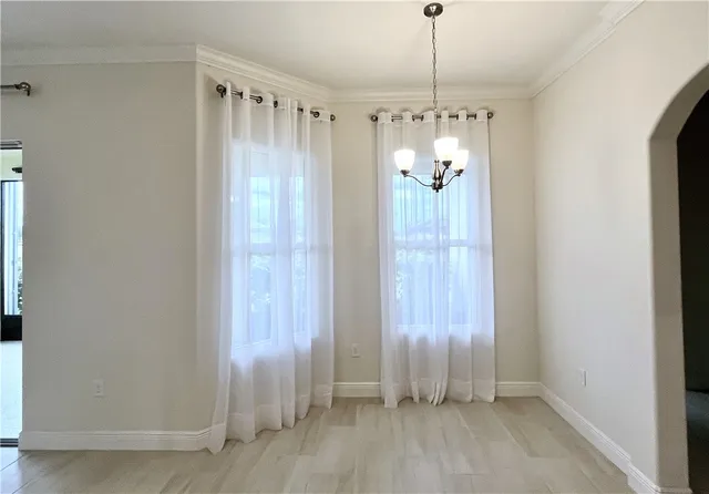 a view of a hallway with chandelier and glass door