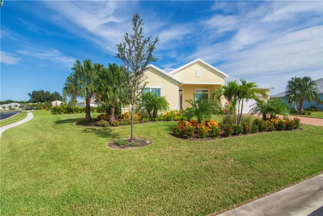 a view of a house with backyard and a tree