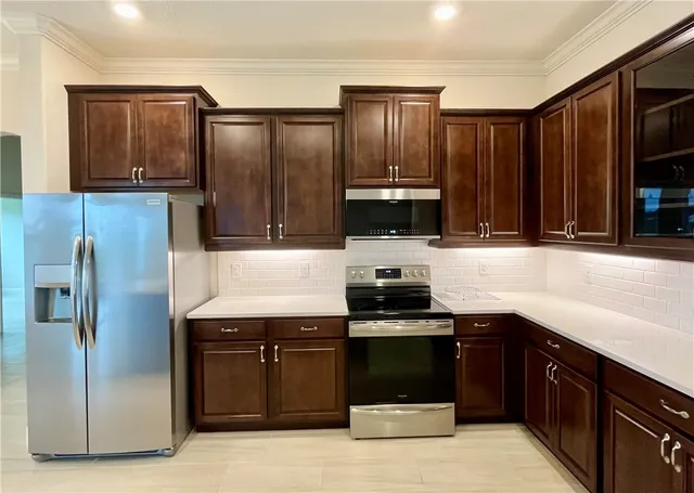 a kitchen with granite countertop a refrigerator and a sink