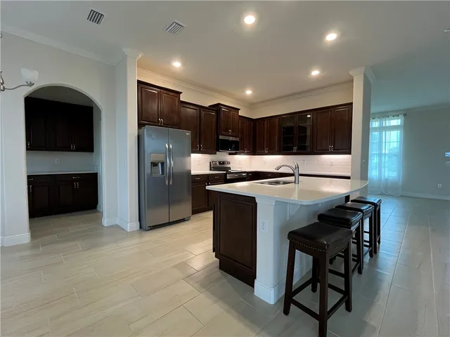 a kitchen with stainless steel appliances kitchen island granite countertop a refrigerator and a stove top oven