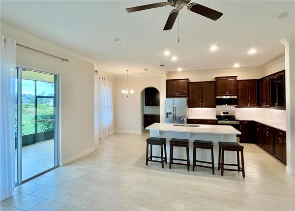 a living room with stainless steel appliances kitchen island granite countertop furniture and a wooden floor