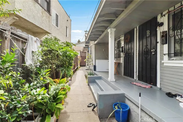 a porch with chairs and potted plant