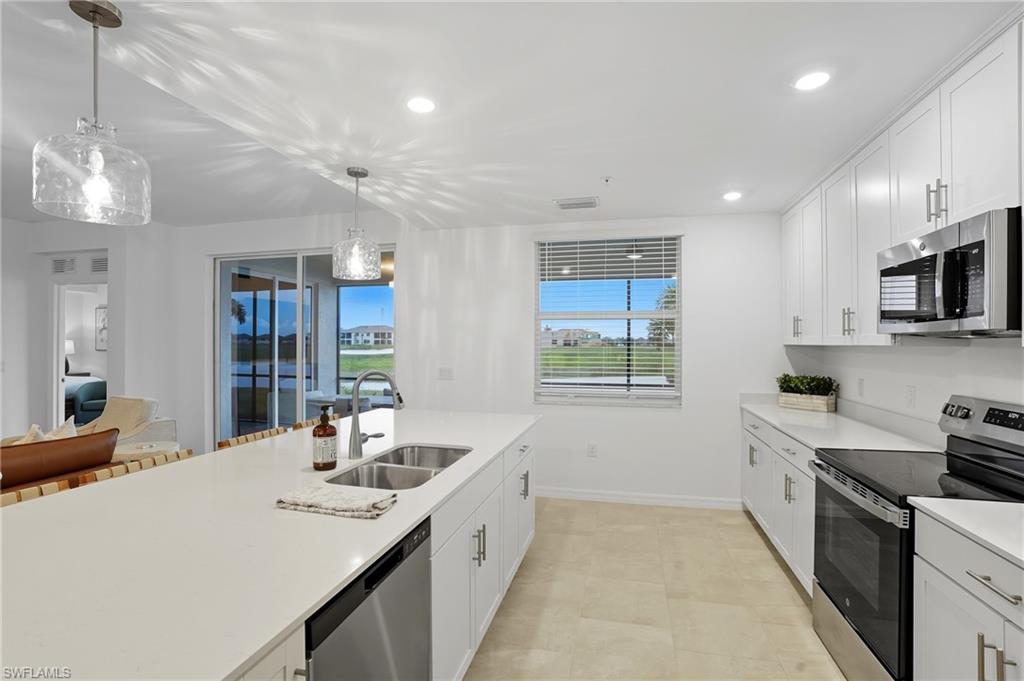 5667 Melbourne Court, Unit 7812 Ave Maria, FL 34142 - Photo 13 of 49 a large kitchen with kitchen island a sink stainless steel appliances and cabinets