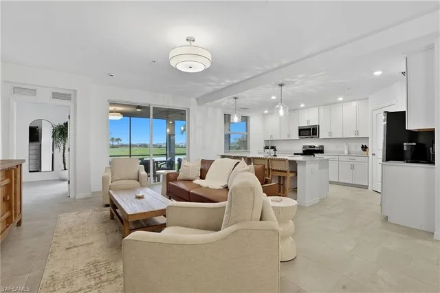 a living room with furniture and kitchen view