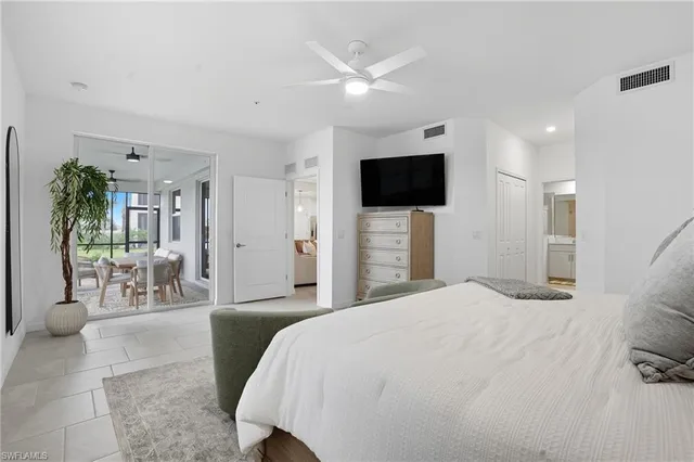 a bedroom with a bed a mirror and a flat screen tv