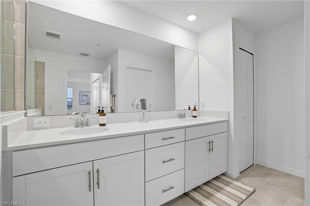 5667 Melbourne Court, Unit 7812 Ave Maria, FL 34142 - Photo 23 of 49 a bathroom with double sink and a mirror