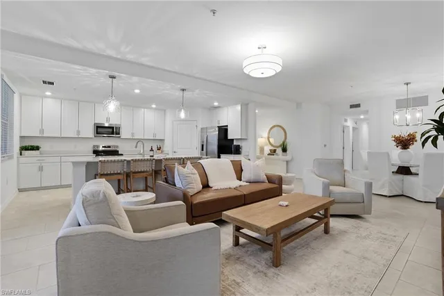 a living room with furniture and a view of kitchen
