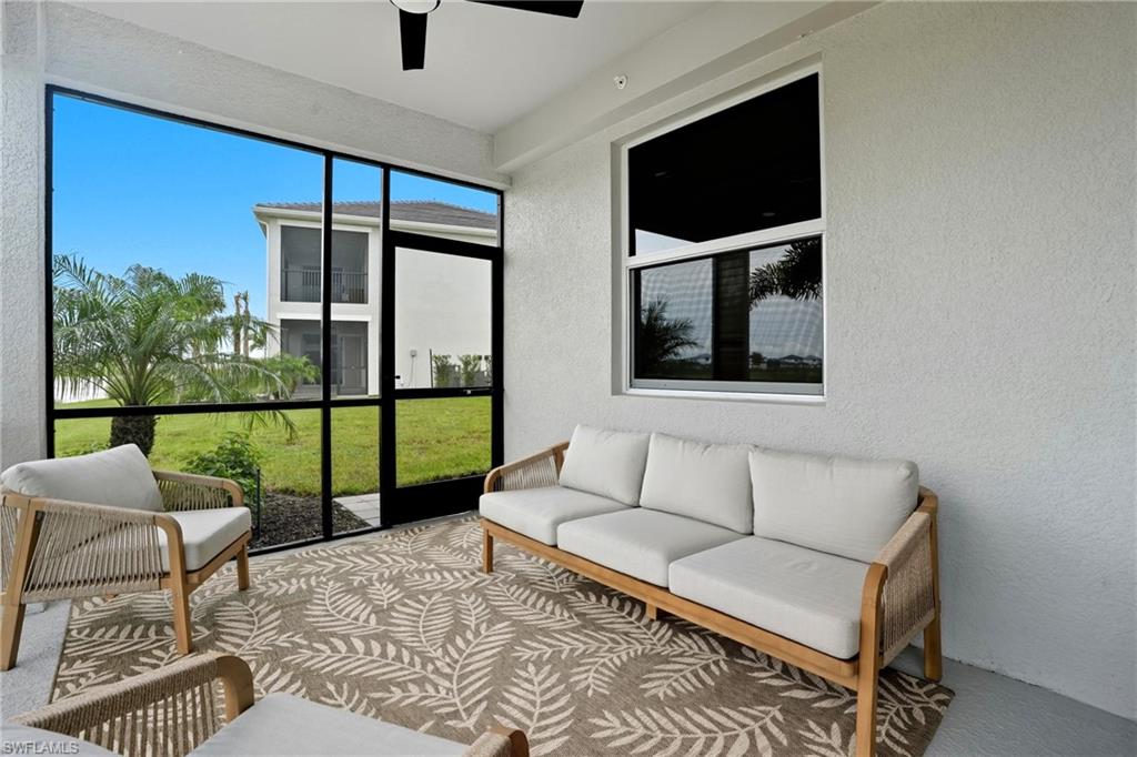 5667 Melbourne Court, Unit 7812 Ave Maria, FL 34142 - Photo 36 of 49 a living room with furniture and a floor to ceiling window