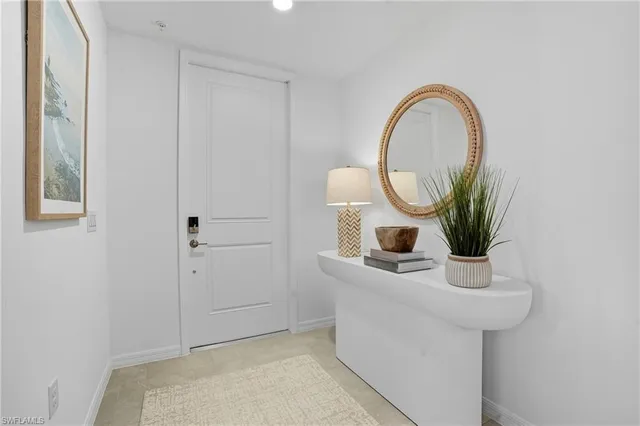 a bathroom with a sink a mirror and a potted plant