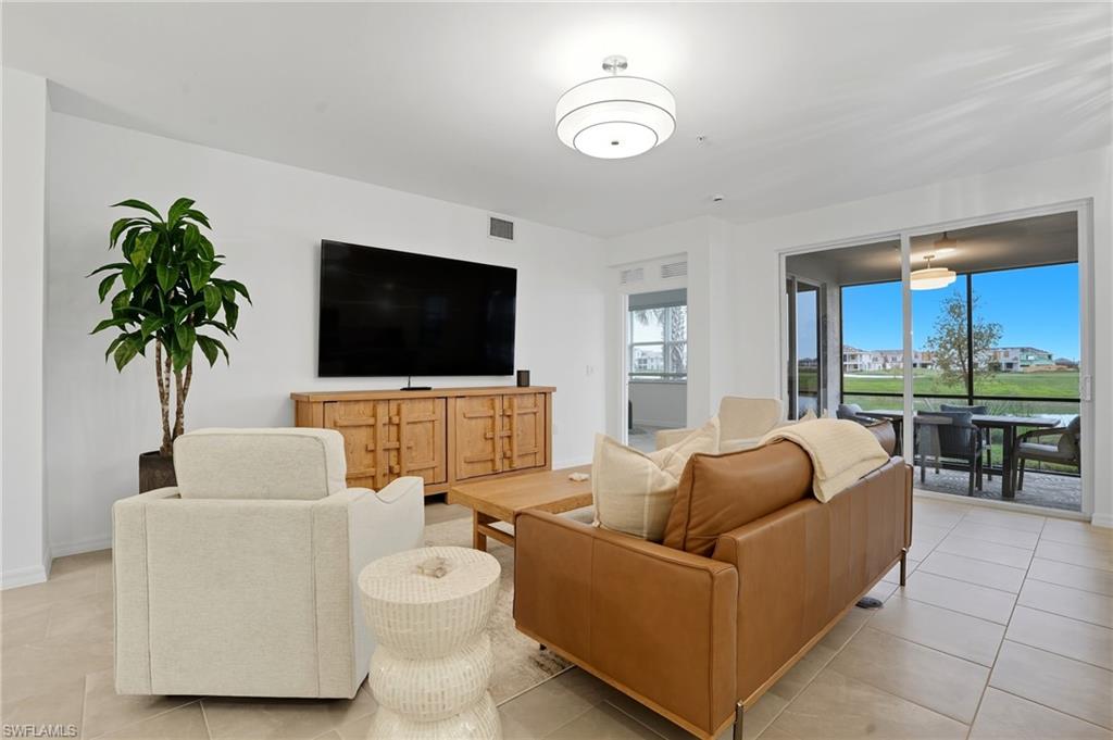 5667 Melbourne Court, Unit 7812 Ave Maria, FL 34142 - Photo 7 of 49 a living room with furniture and a flat screen tv