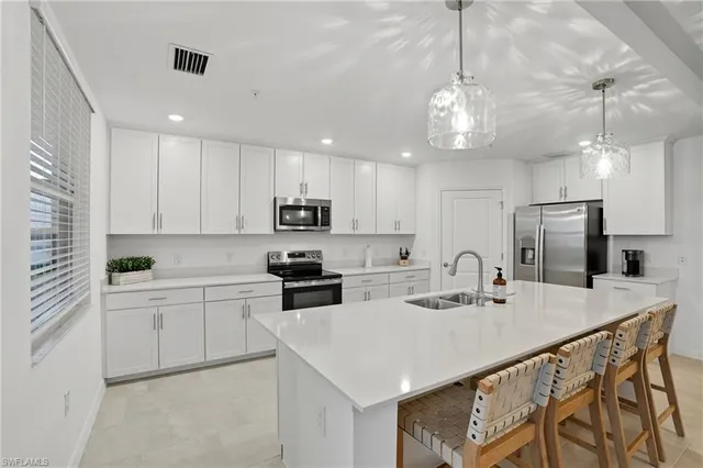 a kitchen that has a lot of cabinets in it and wooden floors