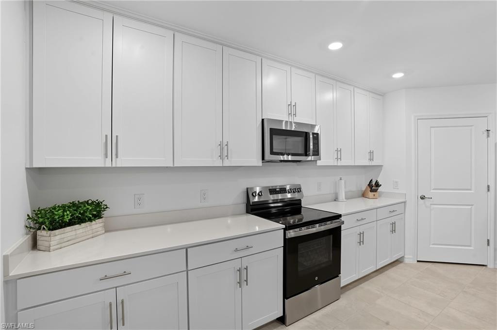 5667 Melbourne Court, Unit 7812 Ave Maria, FL 34142 - Photo 10 of 49 a kitchen with white cabinets and sink