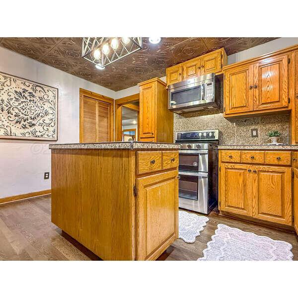 933 Elmore Street Borger, TX 79007 - Photo 19 of 53 a kitchen with stainless steel appliances granite countertop a sink stove and refrigerator
