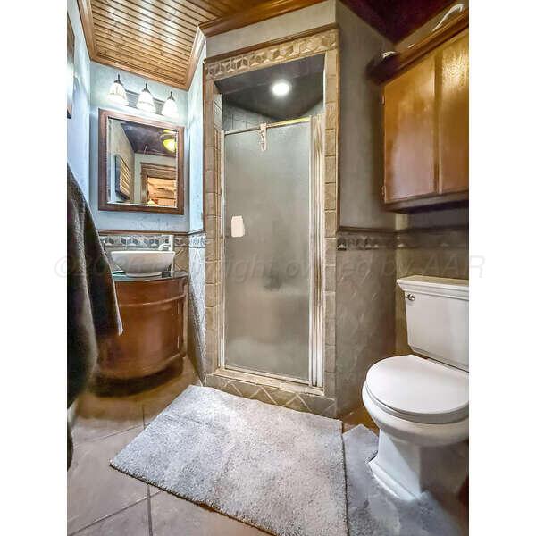 933 Elmore Street Borger, TX 79007 - Photo 25 of 53 a bathroom with a toilet a sink and mirror