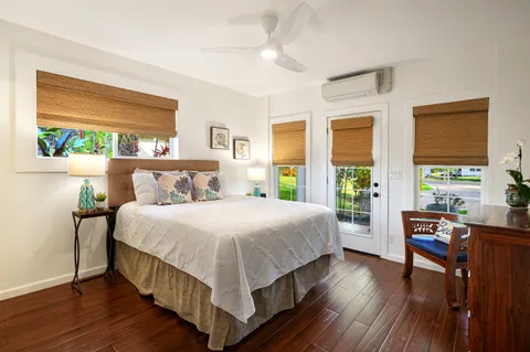 a bedroom with a large bed a large window with table and chairs