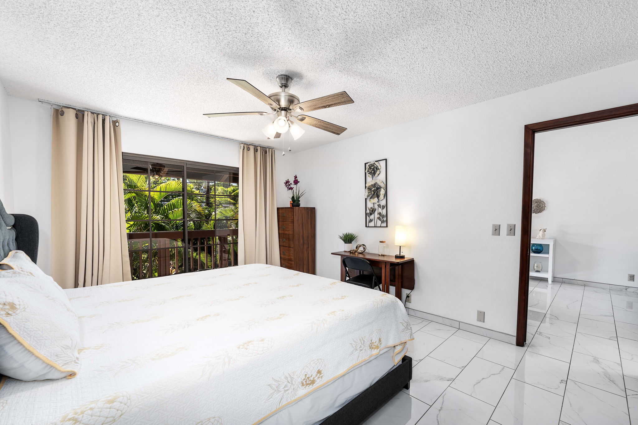 75-123 Lunapule Road, Unit 107 Kailua-Kona, HI 96740 - Photo 7 of 17 a bedroom with a large bed and a chandelier