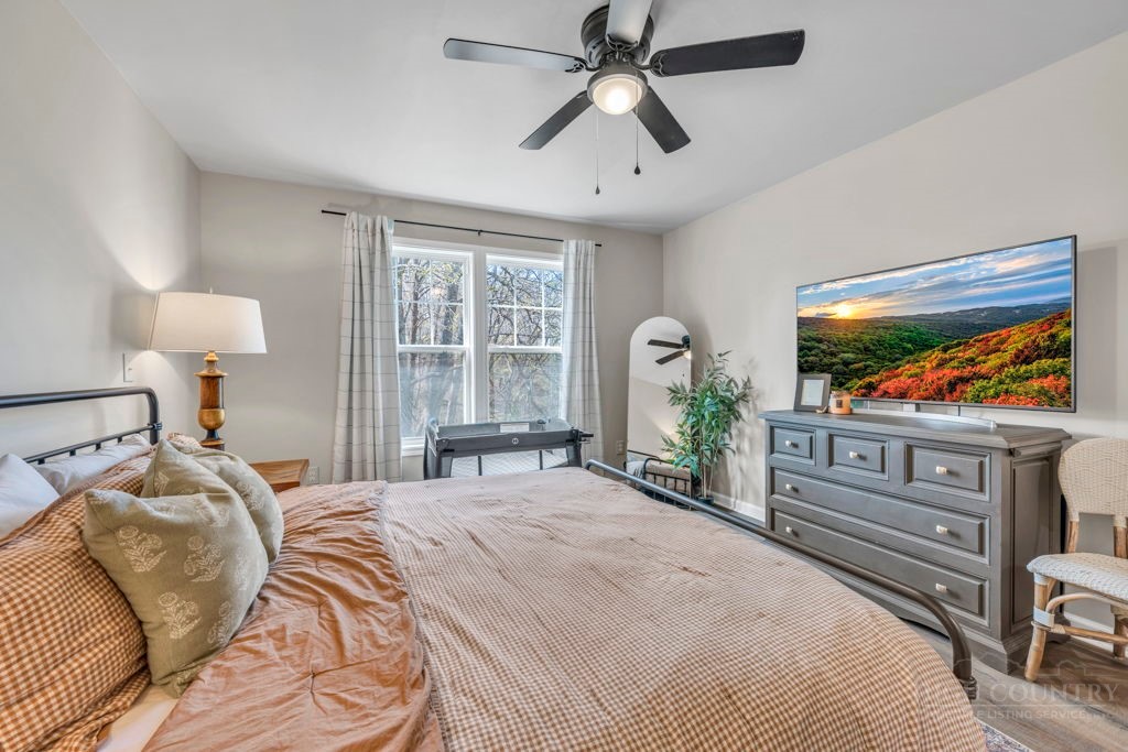 656 Mulatto Mountain Road West Jefferson, NC 28694 - Photo 24 of 35 a bedroom with a bed and a flat screen tv