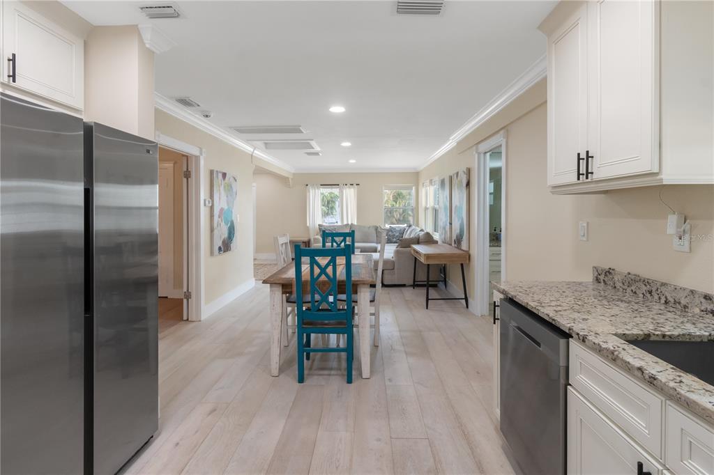 609 North Osceola Avenue Clearwater, FL 33755 - Photo 11 of 47 a kitchen with stainless steel appliances granite countertop table chairs refrigerator and cabinets