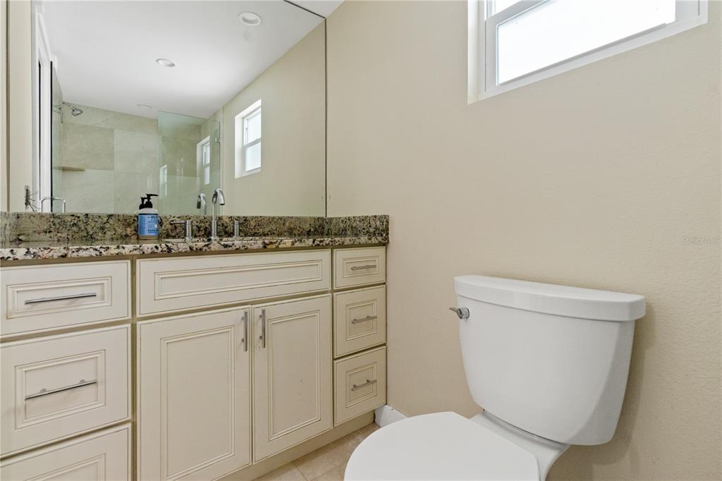 609 North Osceola Avenue Clearwater, FL 33755 - Photo 15 of 47 a bathroom with a granite countertop toilet sink and mirror