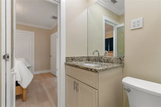 a bathroom with a granite countertop sink and a toilet
