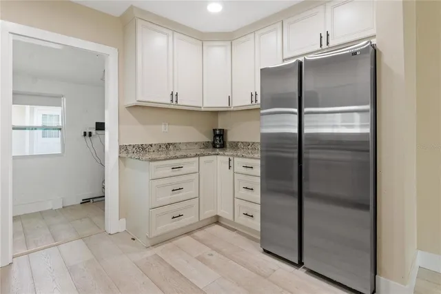 a kitchen with cabinets stainless steel appliances and a window