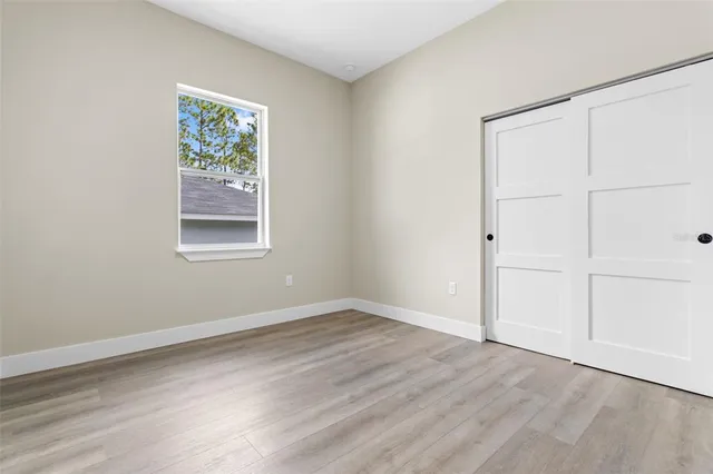 an empty room with wooden floor and window