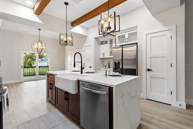a kitchen with stainless steel appliances granite countertop a sink and a refrigerator