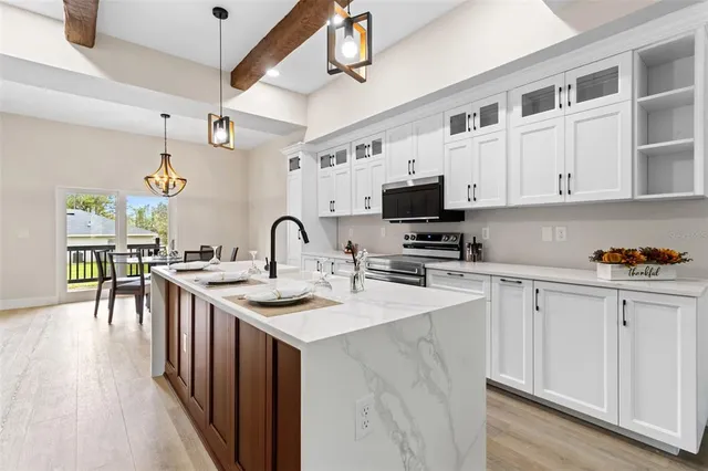 a kitchen with stainless steel appliances granite countertop a sink a stove and cabinets