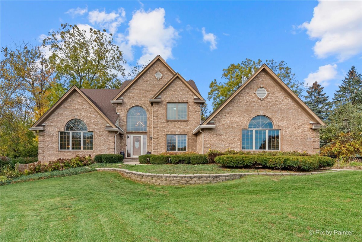 7203 Edgewood Court Spring Grove, IL 60081 - Photo 2 of 46 a front view of a house with a garden and yard