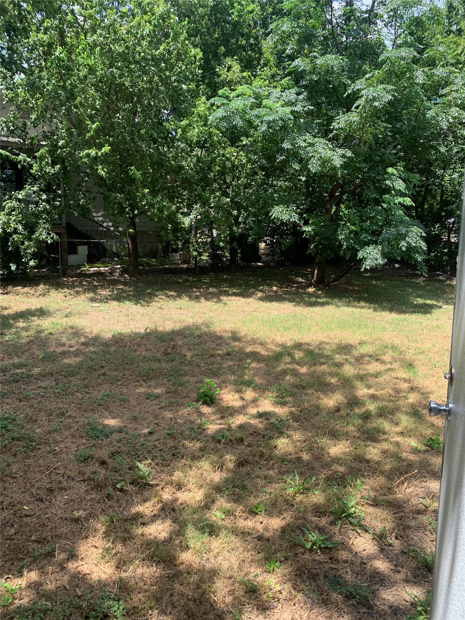 9903 Cheryl Lynn Road Austin, TX 78747 - Photo 2 of 13 A verdant natural landscape with mature trees and ample space awaits your personal touch.