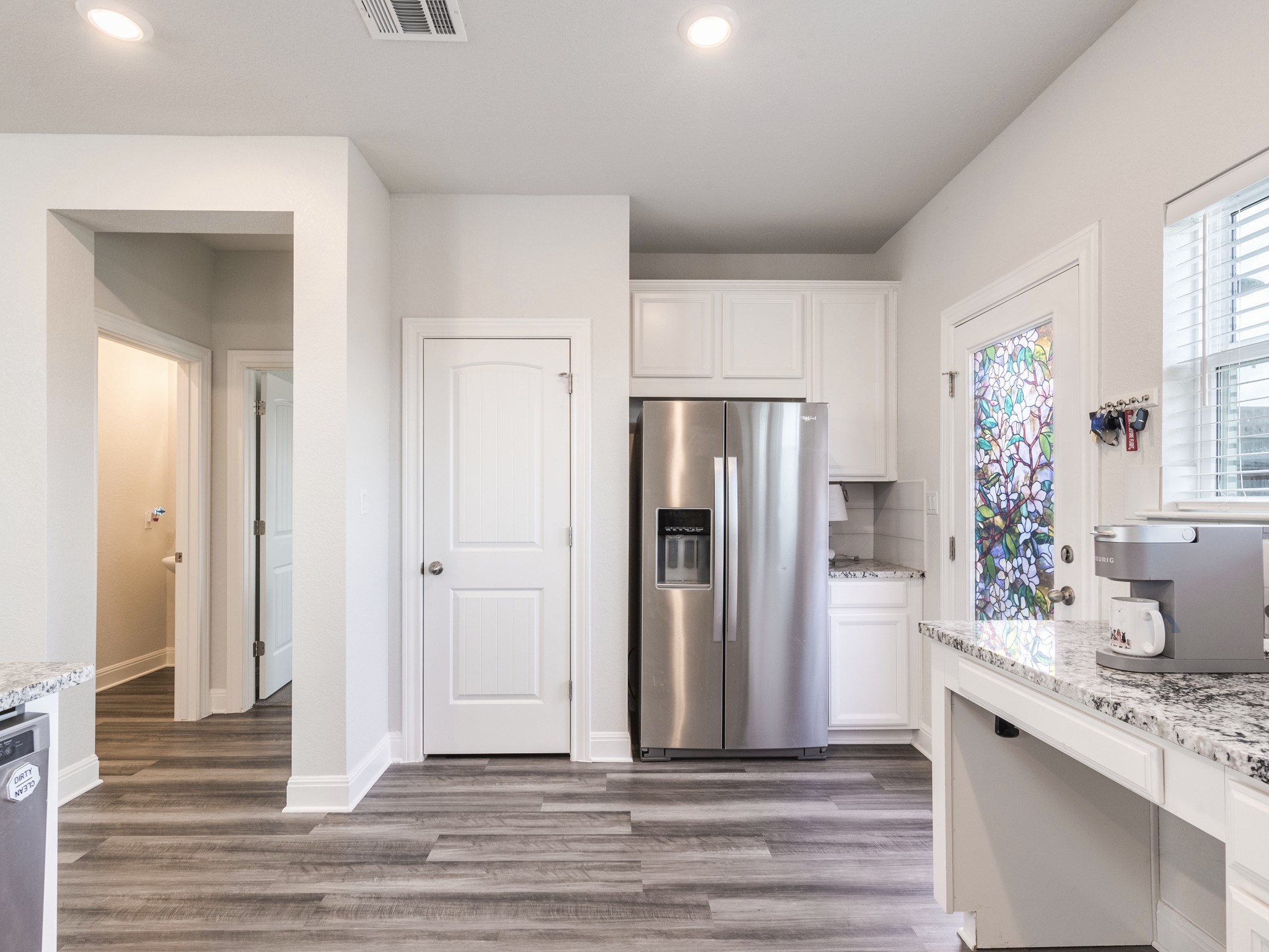 142 Mount Locke Road Dripping Springs, TX 78620 - Photo 10 of 31 a view of a kitchen with refrigerator and wooden floor