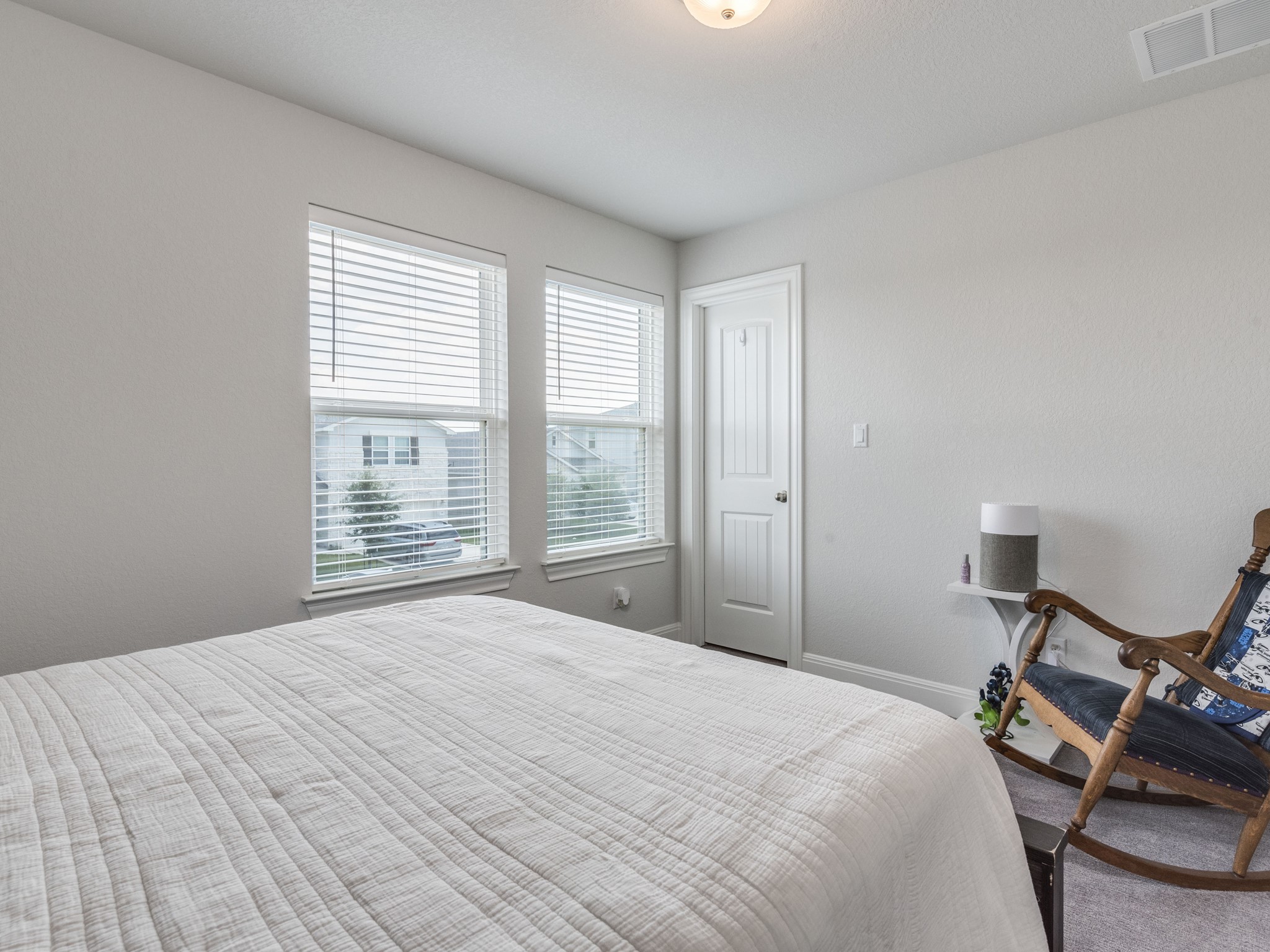 142 Mount Locke Road Dripping Springs, TX 78620 - Photo 19 of 31 a bedroom with a bed and large windows