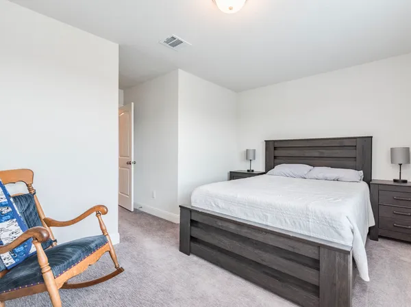 a bedroom with a bed and large windows