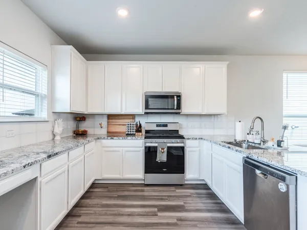a kitchen with a sink stove cabinets and refrigerator