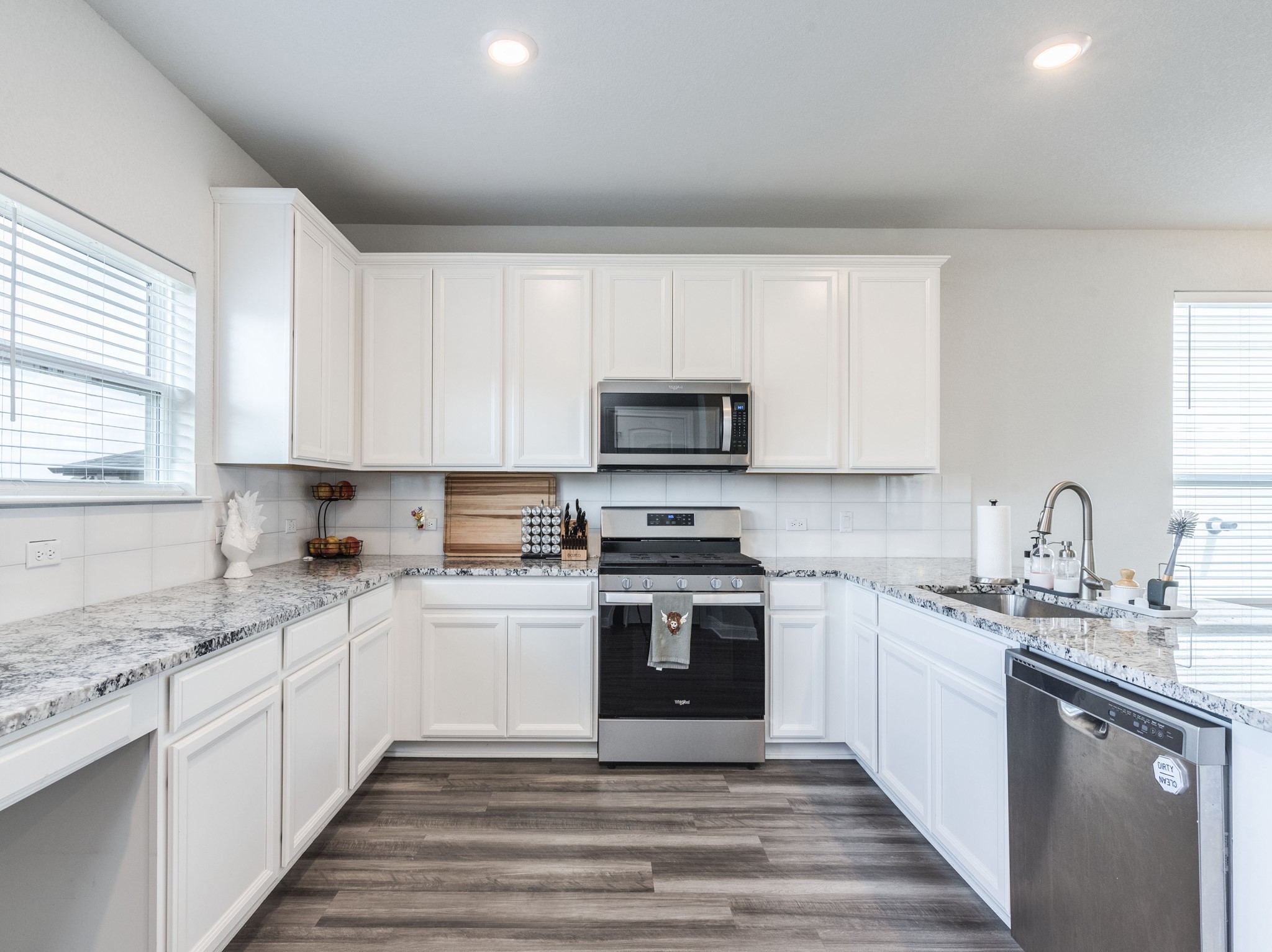 142 Mount Locke Road Dripping Springs, TX 78620 - Photo 9 of 31 a kitchen with stainless steel appliances granite countertop a sink a stove top oven and white cabinets