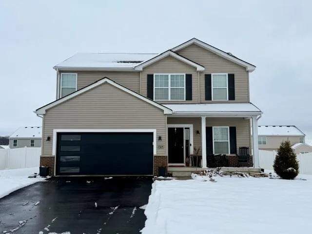 a front view of a house with yard and parking space