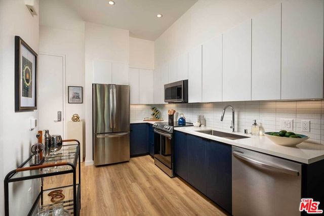 a kitchen with stainless steel appliances granite countertop a refrigerator stove microwave and sink