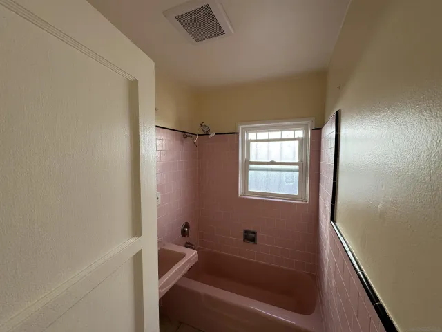 a bathroom with a bathtub and a window