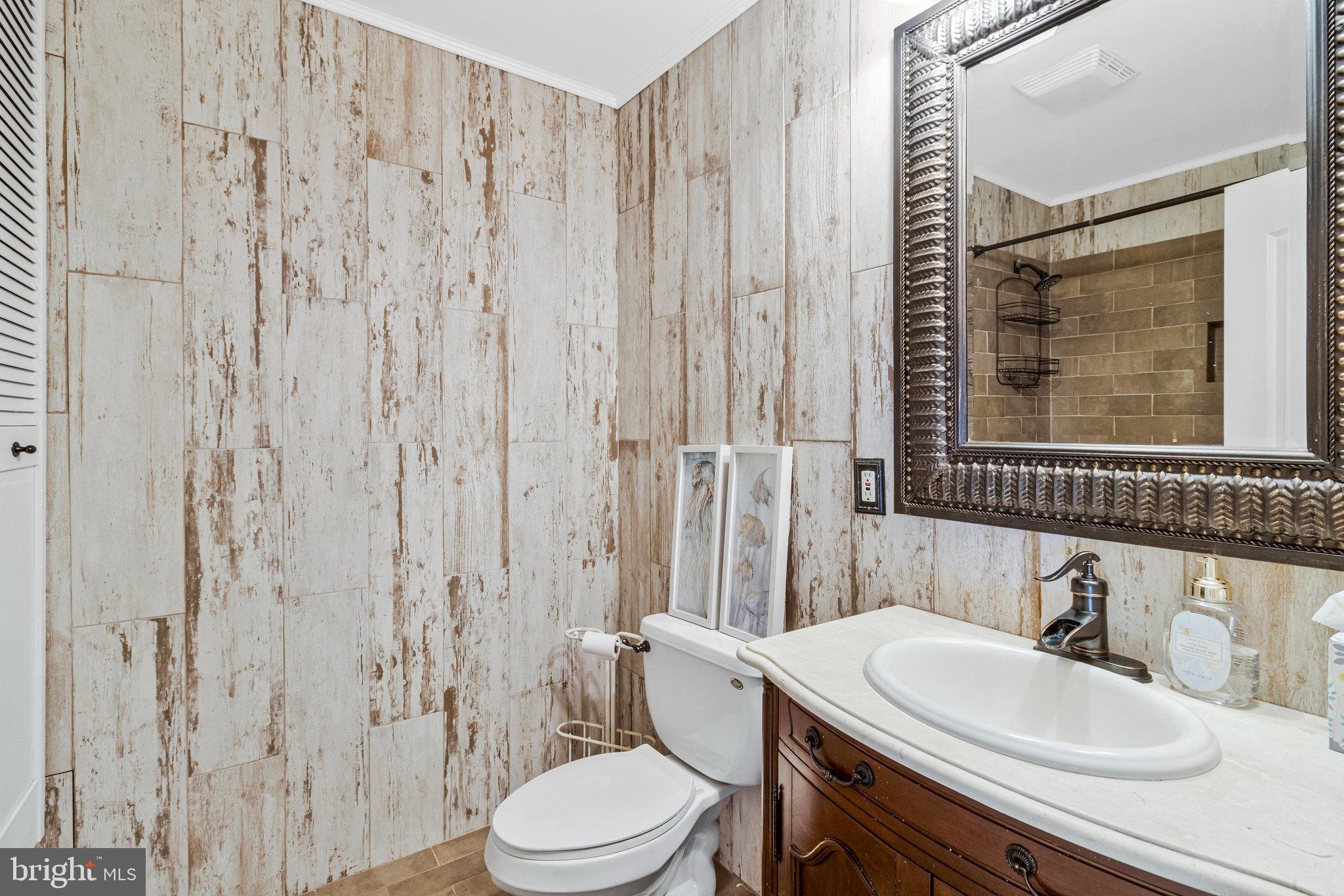 15295 Woodville Road Waldorf, MD 20601 - Photo 17 of 32 a bathroom with a toilet a sink and a mirror