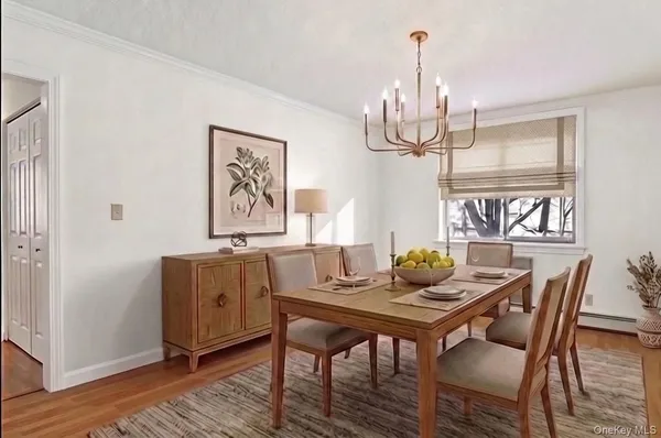 a dining room with furniture a chandelier and wooden floor
