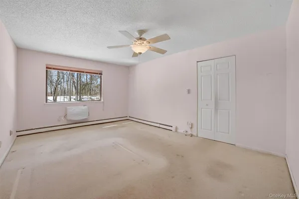 an empty room with windows and fan