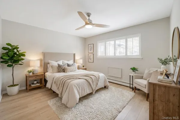 a spacious bedroom with a bed and a potted plant