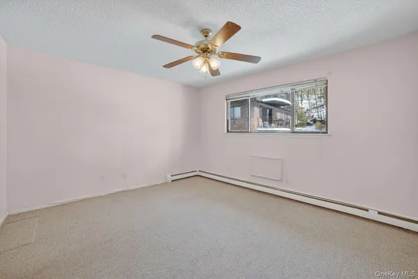 an empty room with a window and a fan