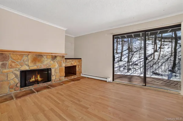 a view of empty room with fireplace and wooden floor