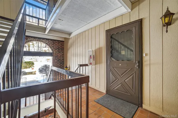 a view of a hallway with wooden floor and stairs