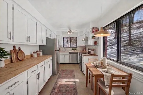 a kitchen with stainless steel appliances granite countertop a stove top oven a sink dishwasher and cabinets with wooden floor
