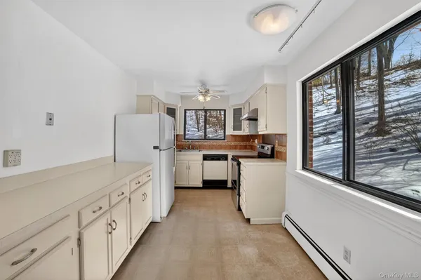 a kitchen with white cabinets and sink