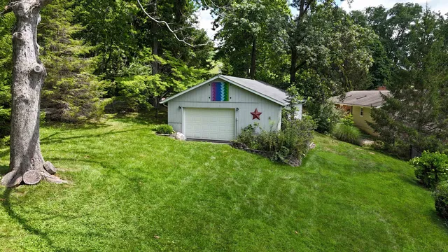 a view of a house with a yard and large trees