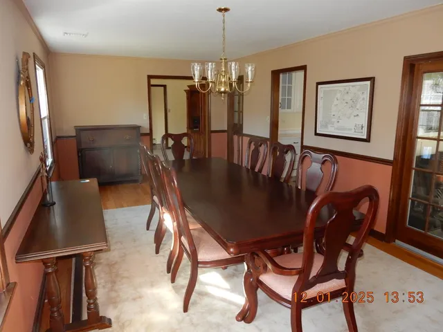 a view of a dining room with furniture and a chandelier