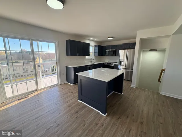 a kitchen with kitchen island a sink appliances and cabinets